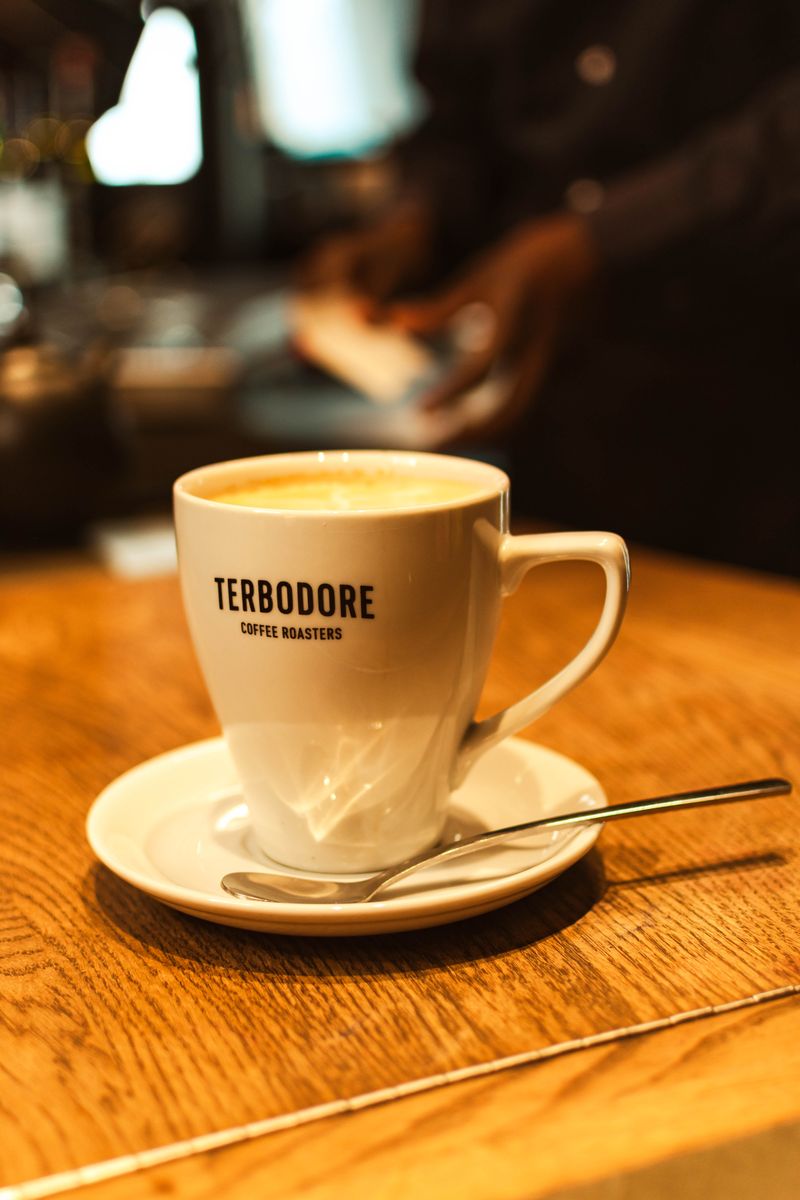 A Terbodore coffee cup and saucer on a wooden table at Prime Wagyu