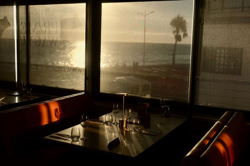 Golden evening light falling across a table by the restaurant windows